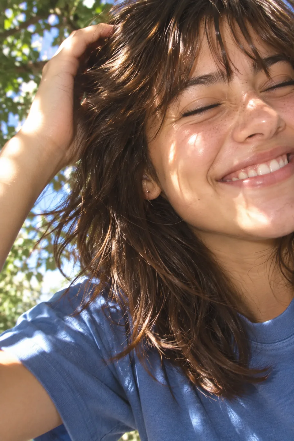 Retrato ilustrativo de una joven sonriendo bajo la luz del sol.